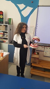 Na zdjęciu znajduje się Pani pielęgniarka, trzymająca w dłoniach model szczęki