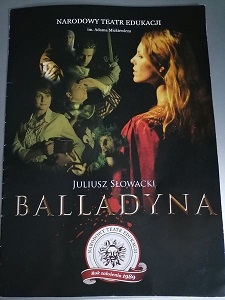 Na zdjęciu znajduje się plakat spektaklu pt. "Balladyna". Ukazane jest tu siedem postaci. Jedna z nich trzyma miecz. Kobieta z przodu ma na sobie bordową pelerynę.