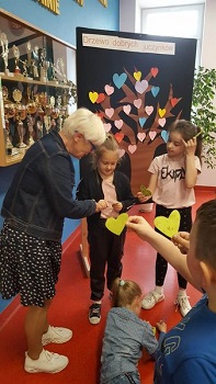 Na zdjęciu znajduje się dyrektor szkoły oraz dzieci z klasy I